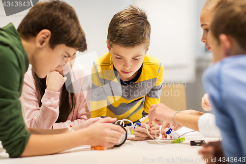 Image of happy children building robots at robotics school