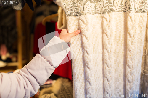 Image of woman buying woolen clothes at christmas market