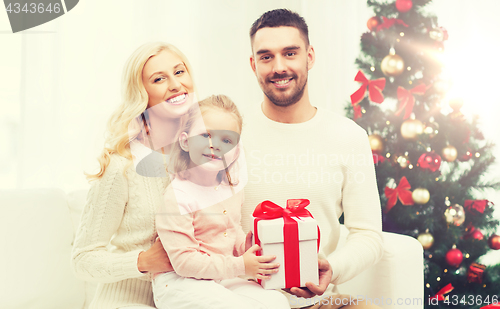 Image of happy family at home with christmas gift box