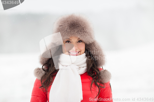 Image of happy smiling woman in winter fur hat outdoors