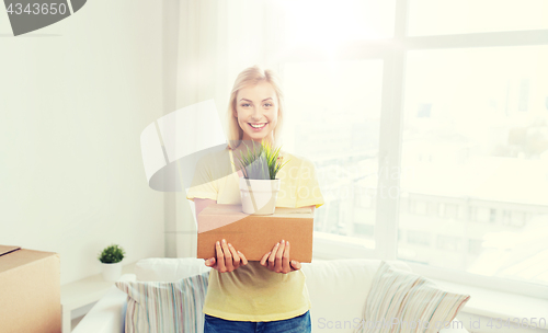 Image of smiling young woman with cardboard box at home