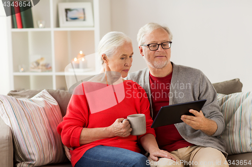 Image of happy senior couple with tablet pc at christmas