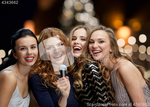 Image of women with microphone singing karaoke at christmas