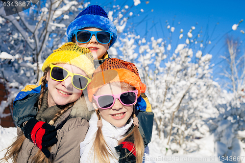 Image of Happy little children playing  in winter snow day.