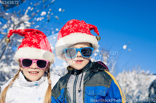 Image of Happy little children playing  in winter snow day.