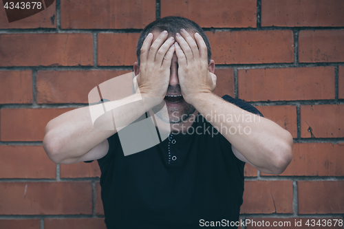 Image of portrait one sad man standing near a wall