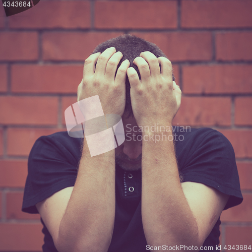 Image of portrait one sad man standing near a wall