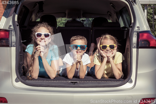 Image of Happy brother and his two sisters are sitting in the car at the 