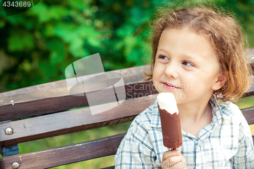 Image of little boy eating ice cream in the park