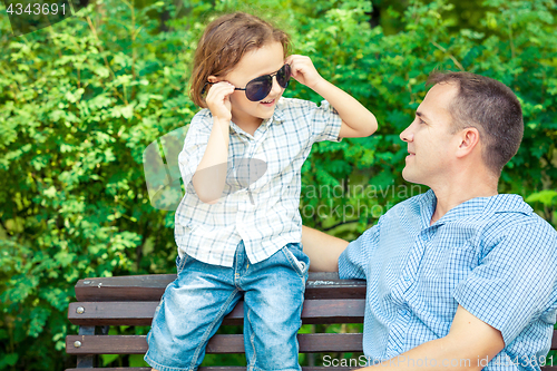 Image of Father and son playing at the park on bench at the day time.