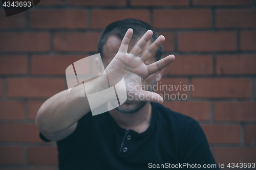 Image of portrait one sad man standing near a wall