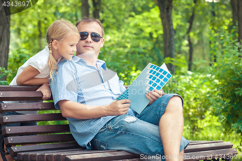 Image of Father and daughter  playing at the park on bench at the day tim