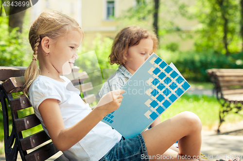 Image of Two happy children  playing in the park at the day time.