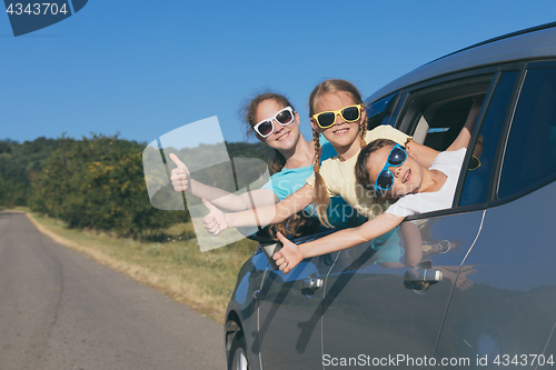 Image of Happy brother and his two sisters are sitting in the car at the 