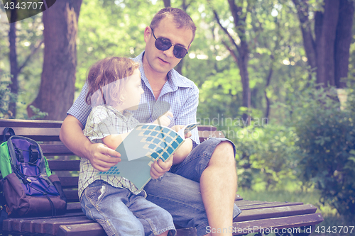 Image of Father and son playing at the park on bench at the day time.