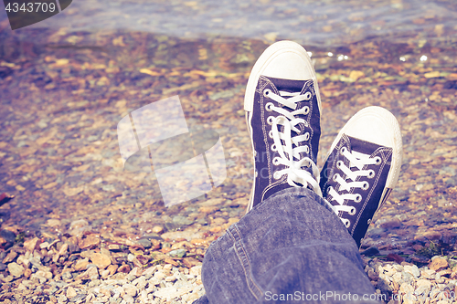 Image of black sneakers on man legs