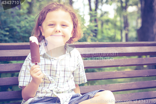 Image of little boy eating ice cream in the park