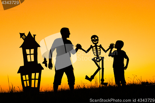 Image of Happy father and son playing outdoors at the sunset time.