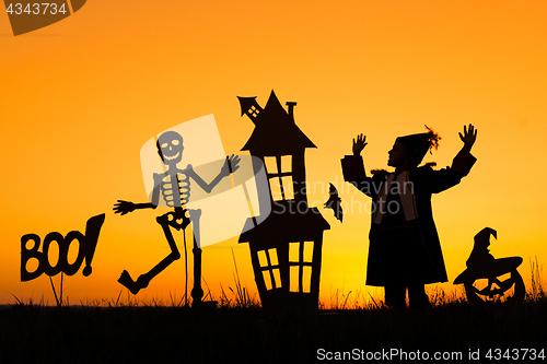 Image of Happy little boy playing outdoors at the sunset time.