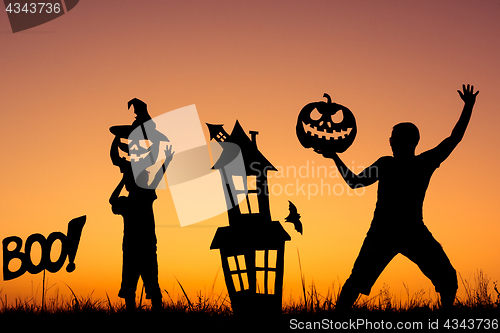 Image of Happy father and son playing outdoors at the sunset time.