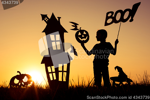 Image of Happy little boy playing outdoors at the sunset time.