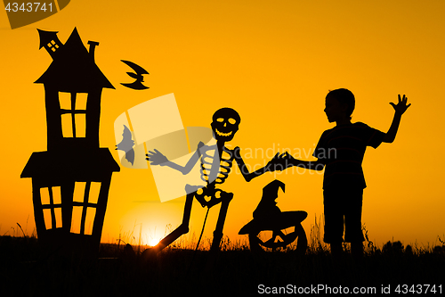 Image of Happy little boy playing outdoors at the sunset time.