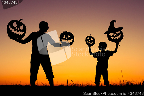 Image of Happy father and son playing outdoors at the sunset time.