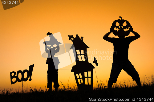 Image of Happy father and son playing outdoors at the sunset time.