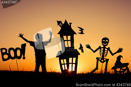 Image of Happy little boy playing outdoors at the sunset time.