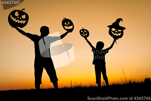 Image of Happy father and son playing outdoors at the sunset time.