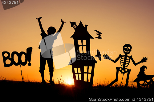 Image of Happy little boy playing outdoors at the sunset time.