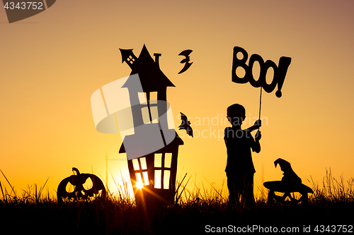 Image of Happy little boy playing outdoors at the sunset time.