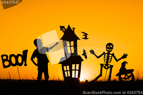 Image of Happy little boy playing outdoors at the sunset time.