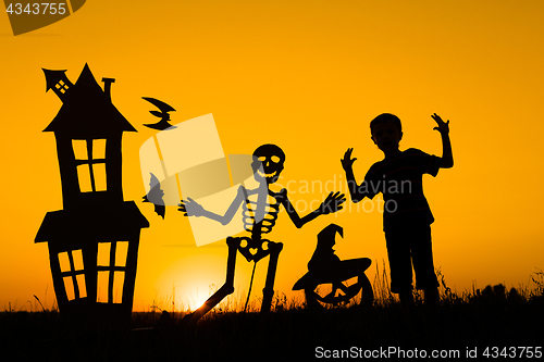 Image of Happy little boy playing outdoors at the sunset time.