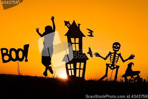 Image of Happy little boy playing outdoors at the sunset time.