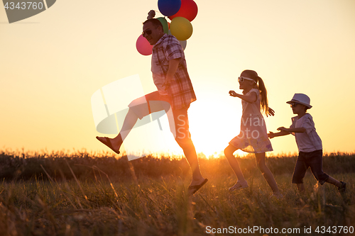 Image of Father and children running on the road at the day time.