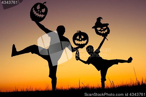 Image of Happy father and son playing outdoors at the sunset time.