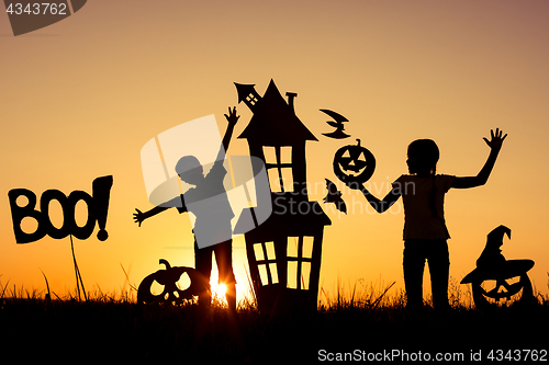 Image of Happy brother and  sister playing outdoors at the sunset time.