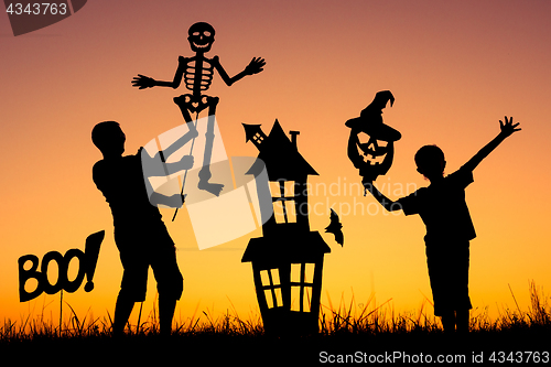 Image of Happy father and son playing outdoors at the sunset time.