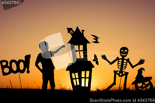 Image of Happy little boy playing outdoors at the sunset time.