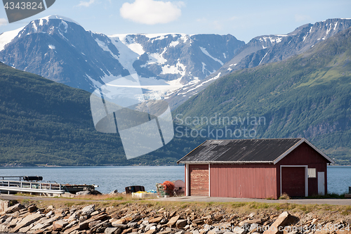 Image of red barn on Norway fjord shore