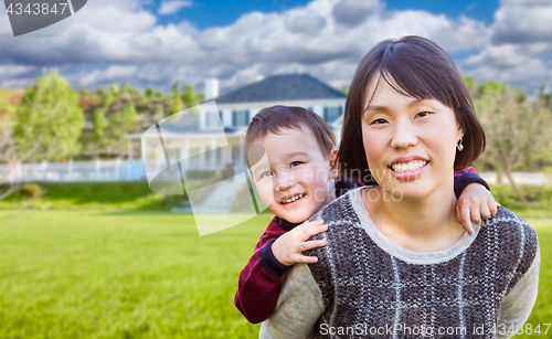 Image of Chinese Mother and Mixed Race Child In The Front Yard of Custom 