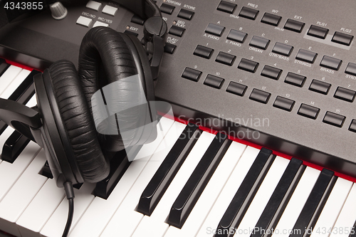 Image of Listening Headphones Laying on Electronic Synthesizer Keyboard