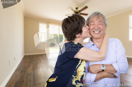 Image of Happy Senior Chinese Couple Kissing Inside Empty Room Of New Hou