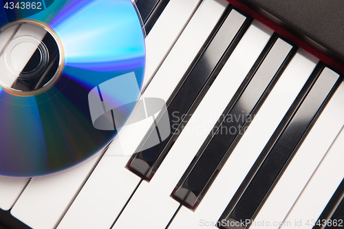 Image of CD Laying on Piano Keyboards Abstract