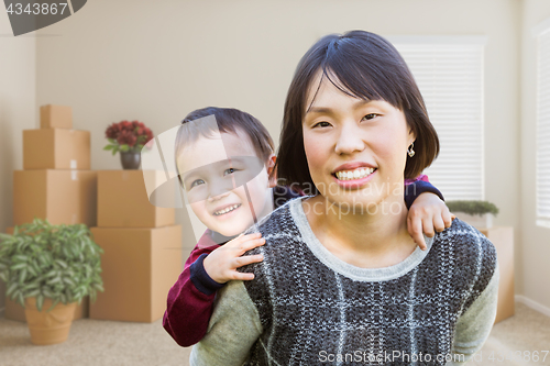Image of Chinese Mother and Mixed Race Child Inside Empty Room with Movin