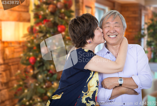 Image of Happy Senior Chinese Couple Kissing In Front of Decorated Christ