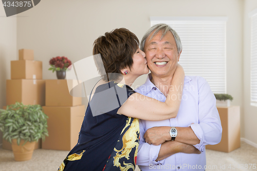 Image of Happy Senior Chinese Couple Inside Empty Room with Moving Boxes 