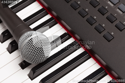 Image of Microphone Laying on Electronic Synthesizer Keyboard Abstract