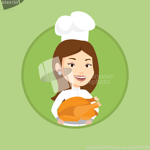 Image of Chef cook holding roasted chicken.